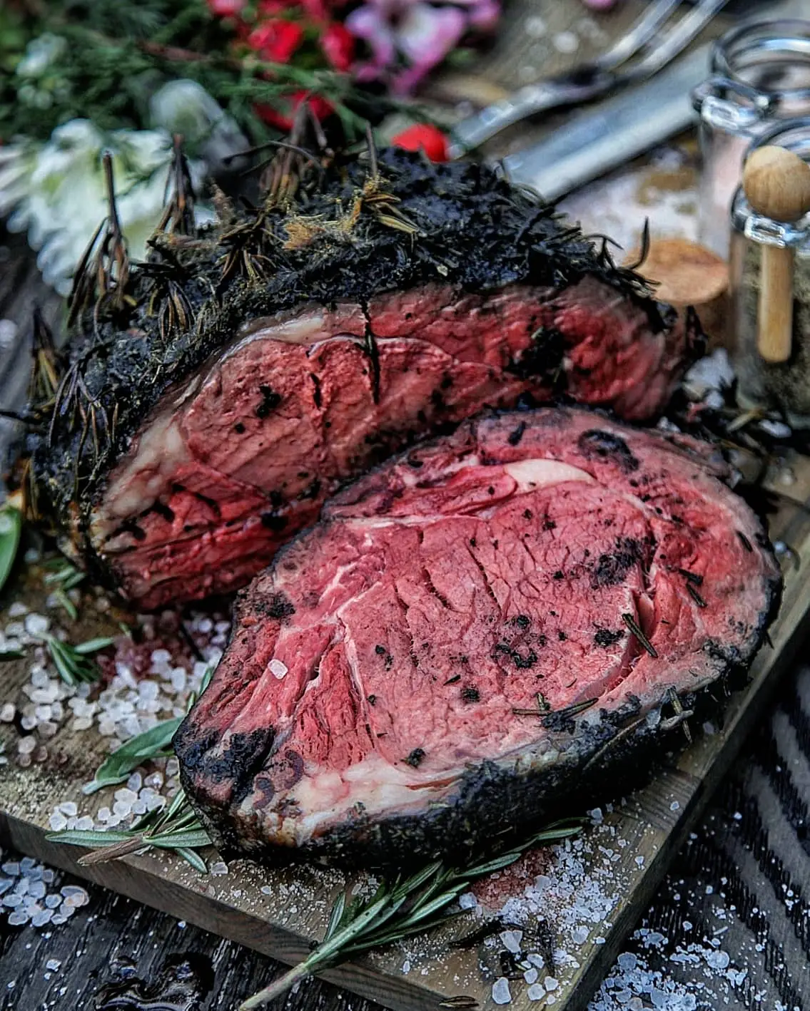 Juicy herb-crusted roast beef with rosemary and sea salt on a wooden board, perfect for gourmet dining.