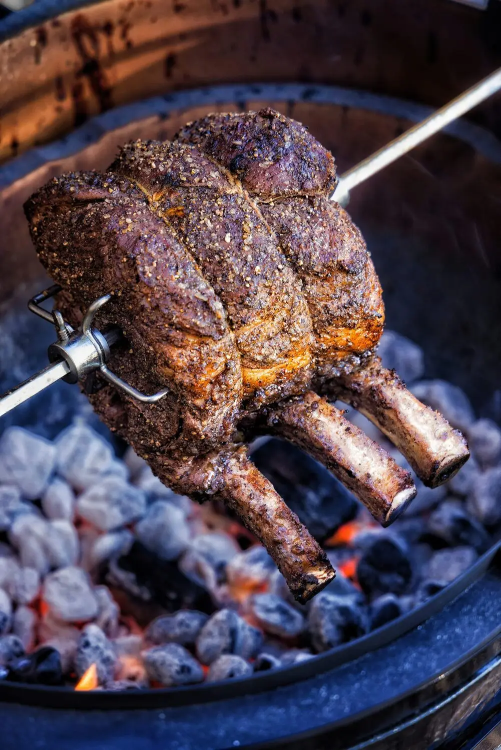 Juicy roast beef on a rotisserie, seasoned perfectly, sizzling over glowing coals for a delicious barbecue.