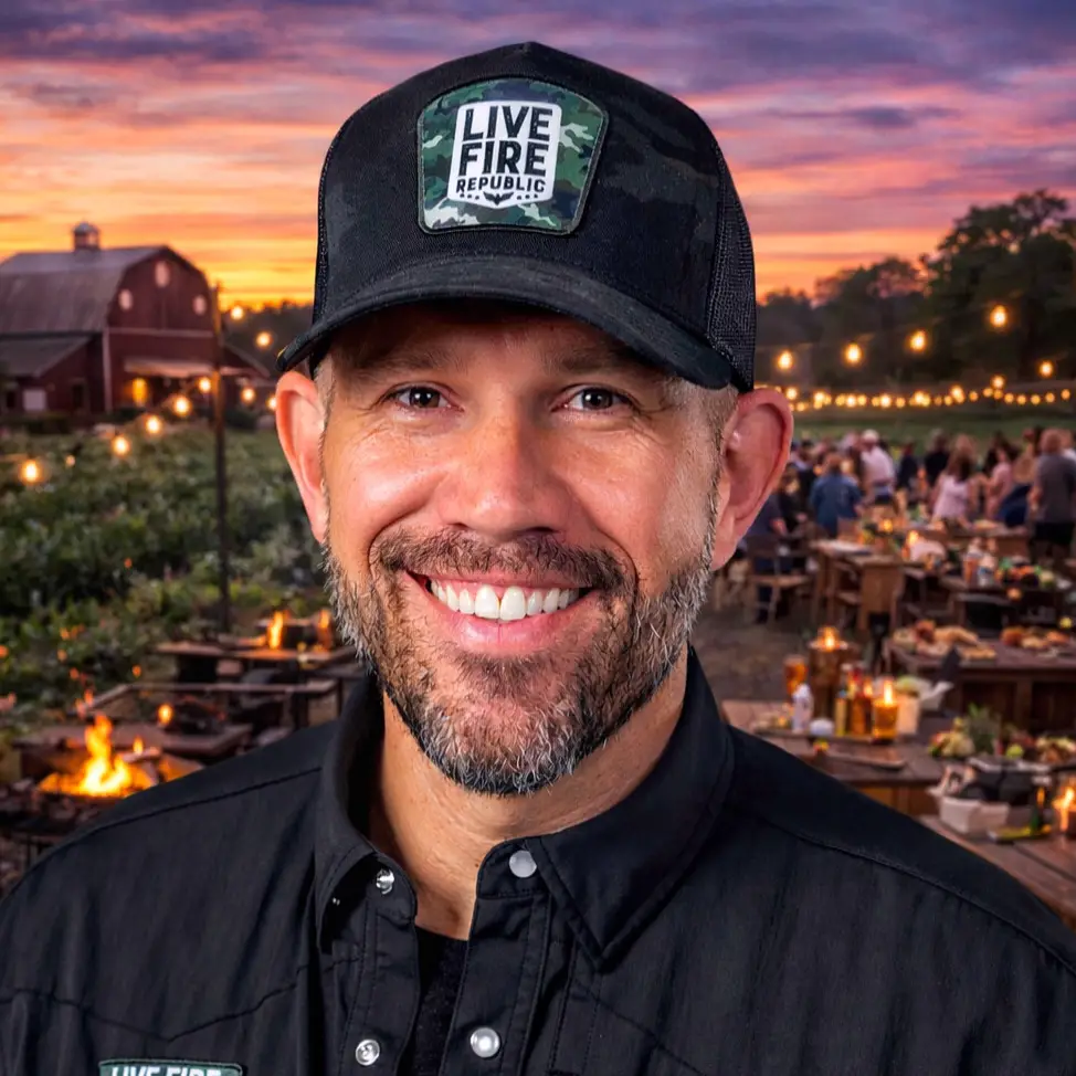 David Olson in Live Fire Republic cap smiling at outdoor event with sunset and barn backdrop.