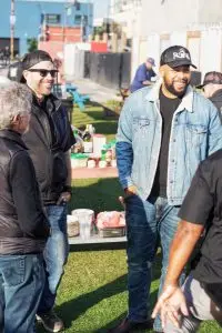 Men socializing beside outdoor food table