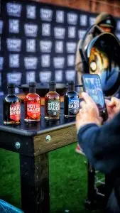 Four condiment bottles photographed beside barbecue grills
